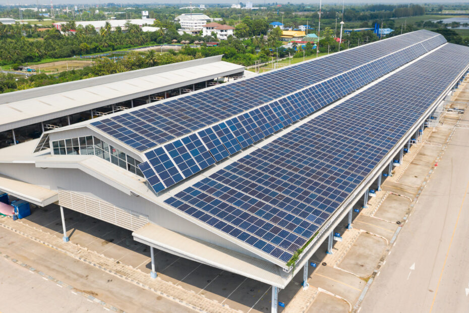 Aerial top view of the solar cells on the roof, Solar panels installed on a roof of a large industrial building or a warehouse taken with the drones